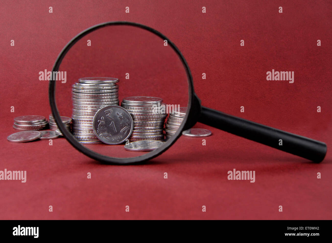 Magnifying glass and coins Stock Photo