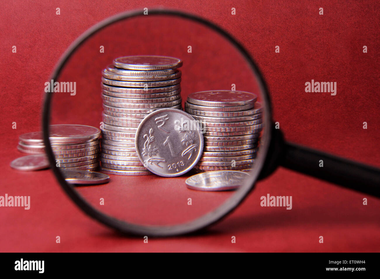 concept of Magnifier and coin Stock Photo