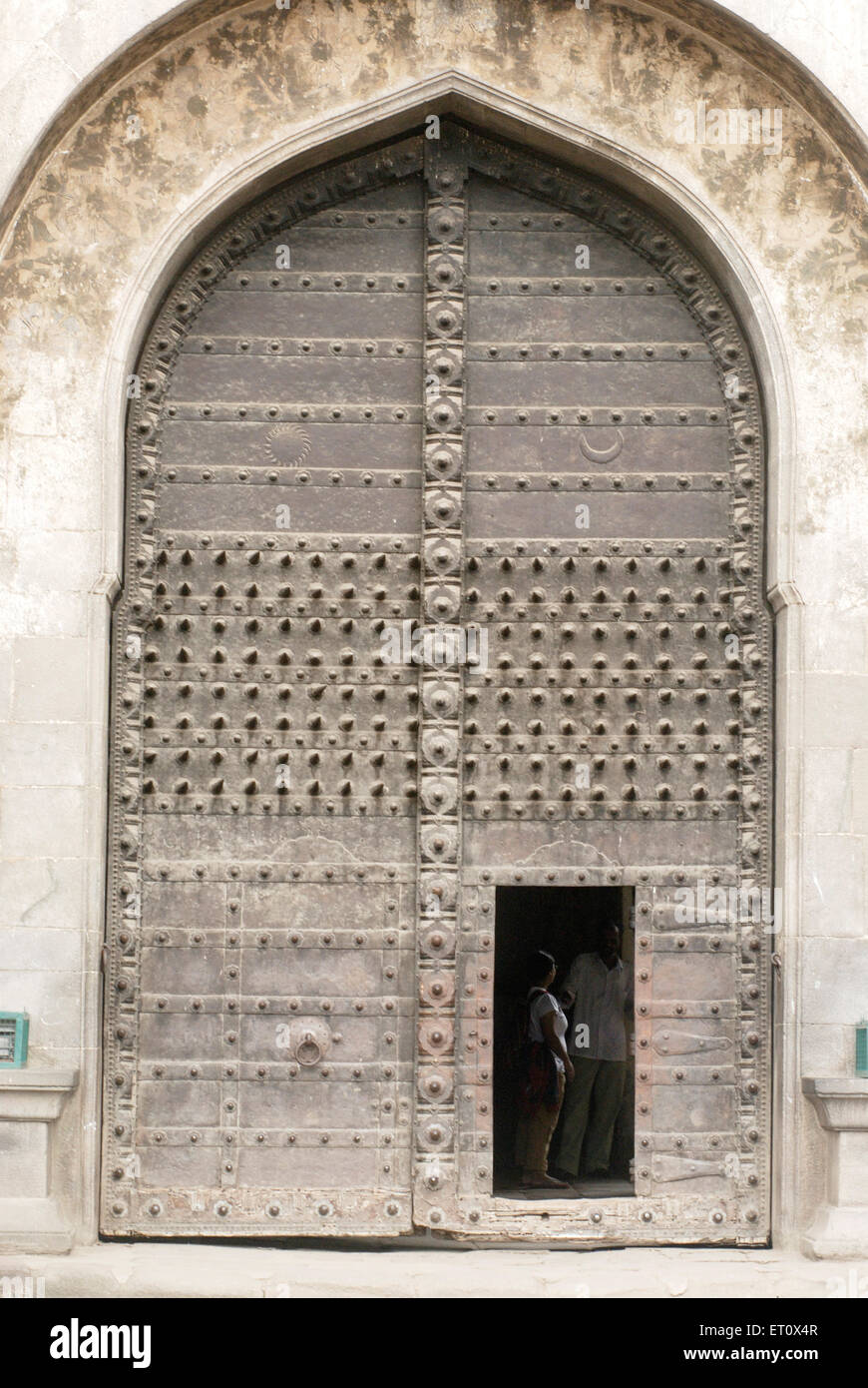 Big spikes rivets fitted on strong ; huge main entrance gate small wicket gate (dindi darwaja) of Shaniwarwada ; Pune Stock Photo