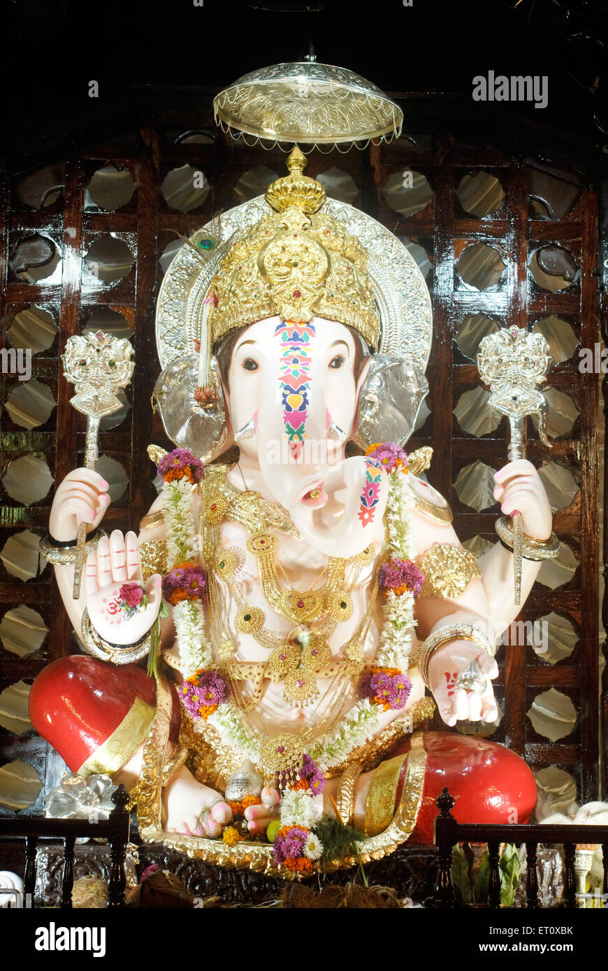 Richly decorated idol of Lord Ganesh kept in gaily decorated frame elephant headed god ; Ganapati festival year 2008 at Pune Stock Photo