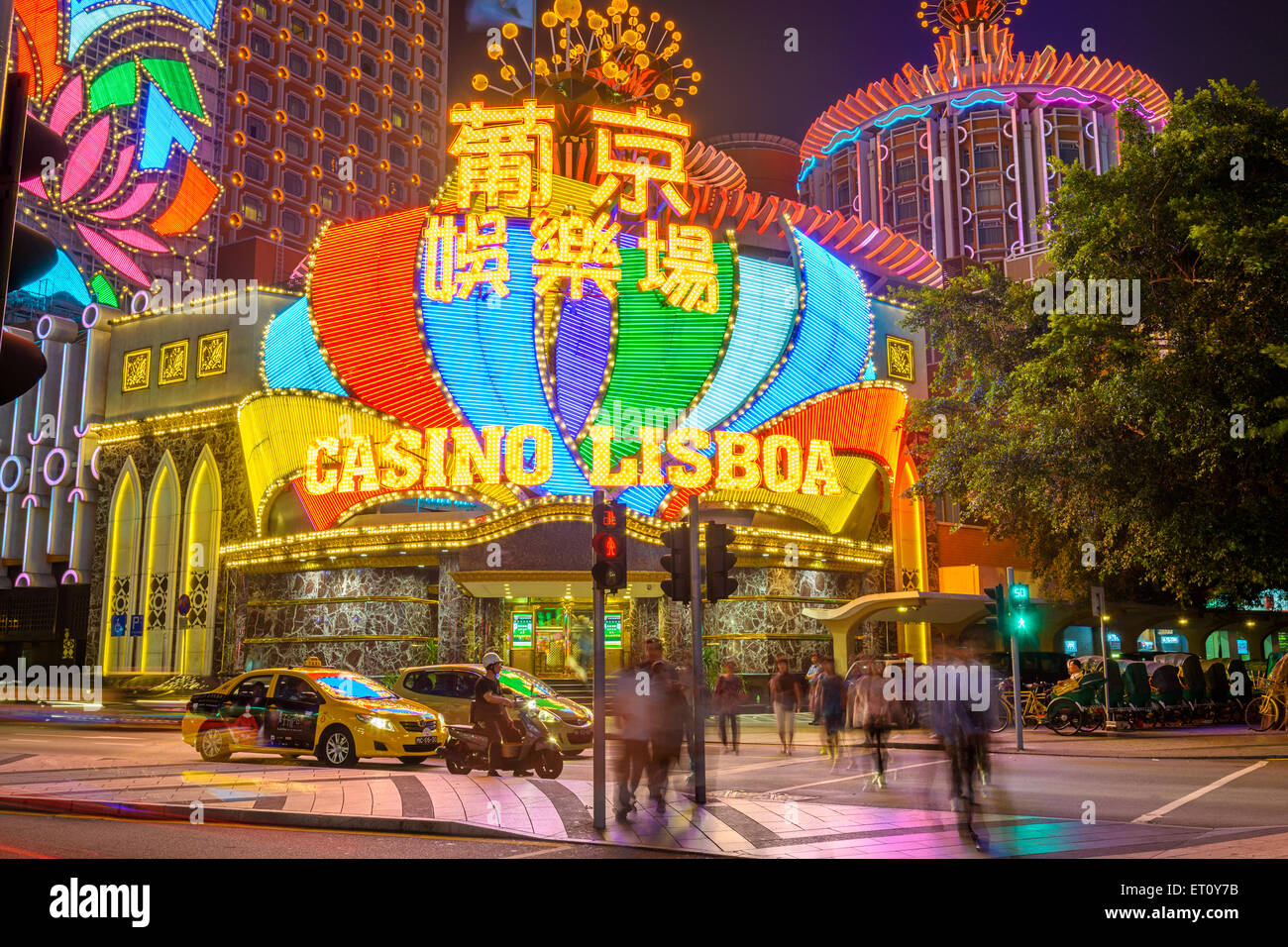 Crowds and traffic pass the exterior of Casino Lisboa in Macau, China. Stock Photo