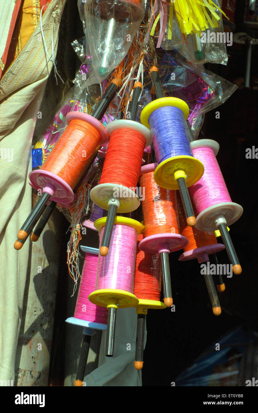 Reels of colourful manja thread outside shop for sell celebrating Makara Sankranti festival ; Bombay Mumbai Stock Photo