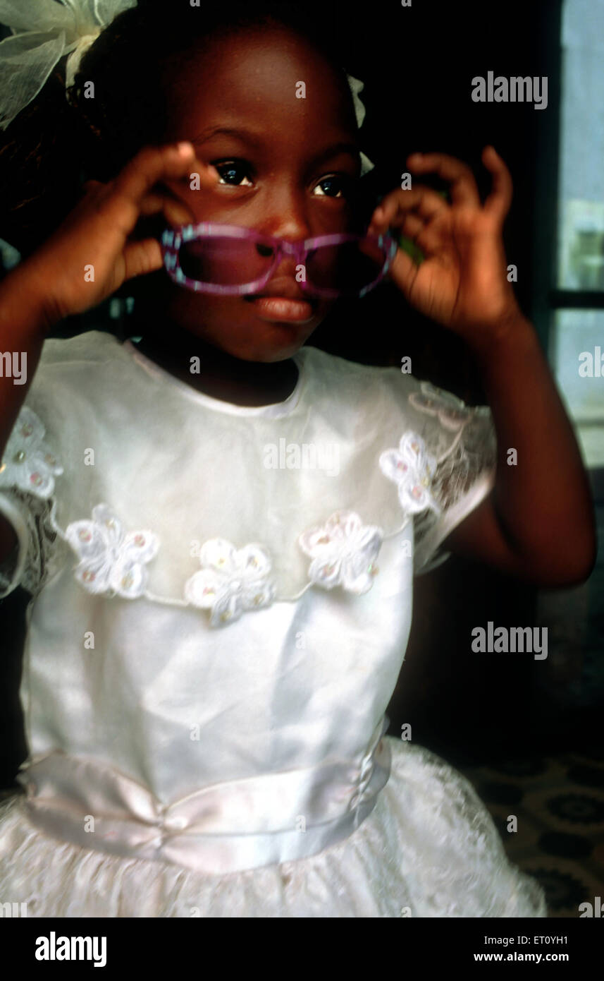 Little girl in Sunday best clothes on step in the street Havana Cuba Stock Photo