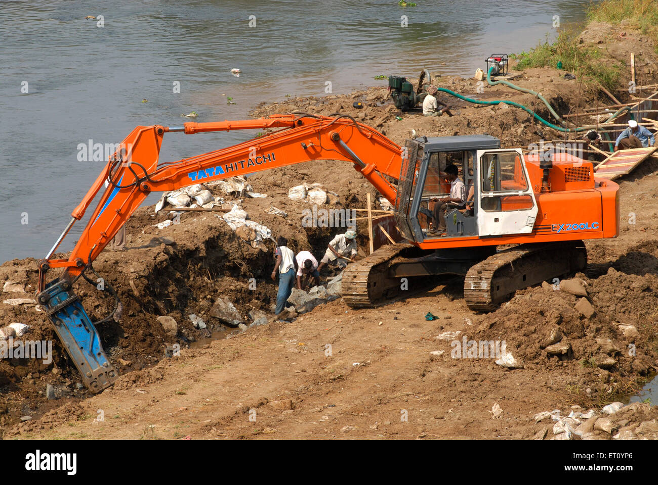 Excavator and digger Bulldozer of TATA HITACHI EX 200 LC heavy machinery ;  excavation work at bank of river Mutha ; Pune Stock Photo