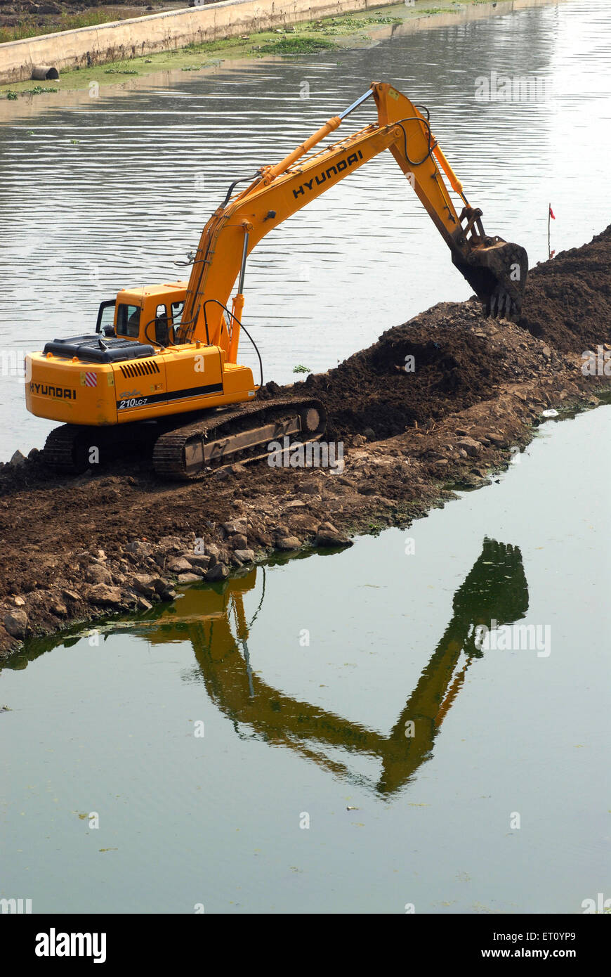 Excavator and digger Bulldozer of HYUNDAI Rolex 210 LC 7 heavy machinery ;  excavation work at bank river Mutha Pune Stock Photo