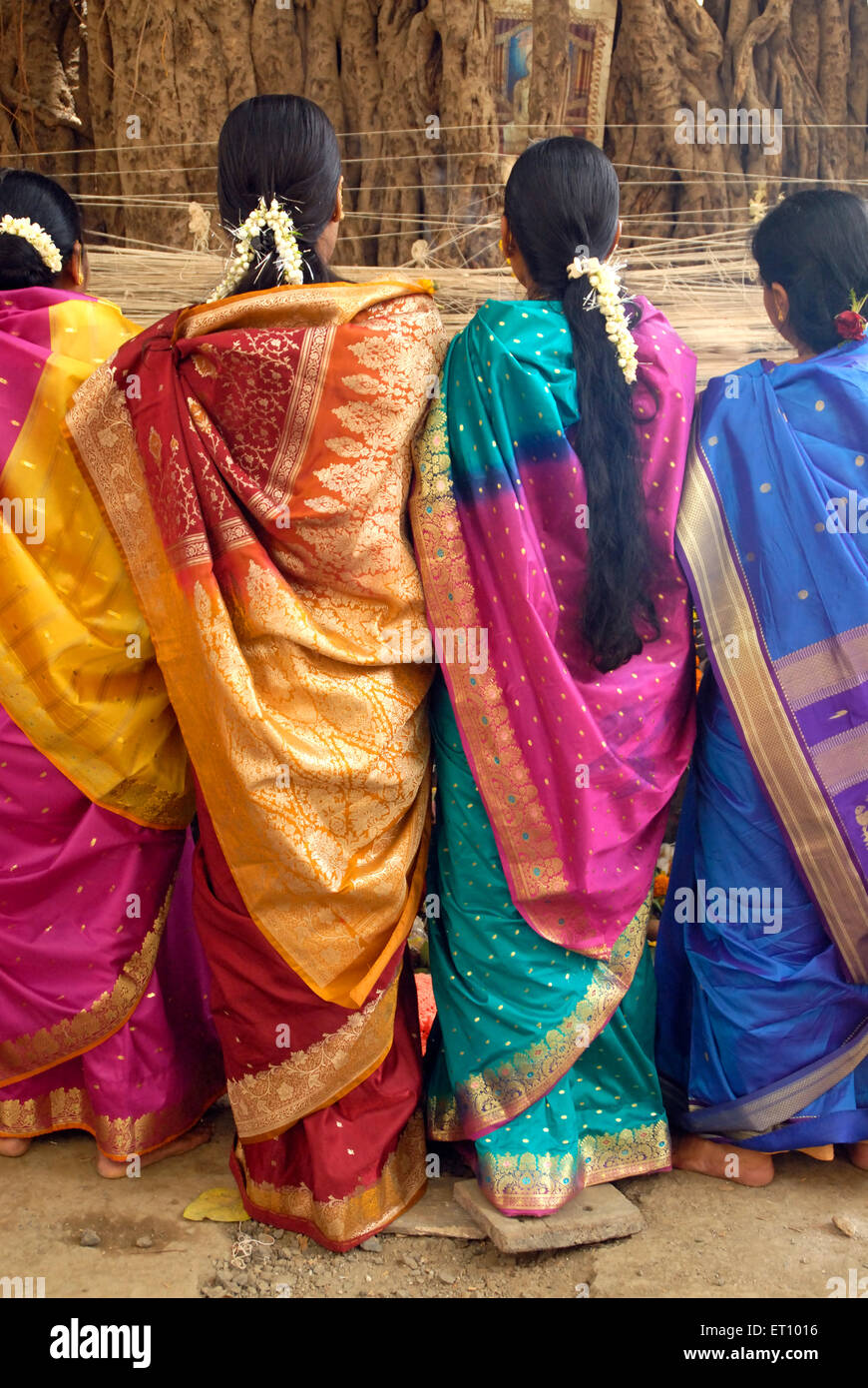 Women tying thread to banyan tree worshipping on vat savitri festival Stock Photo