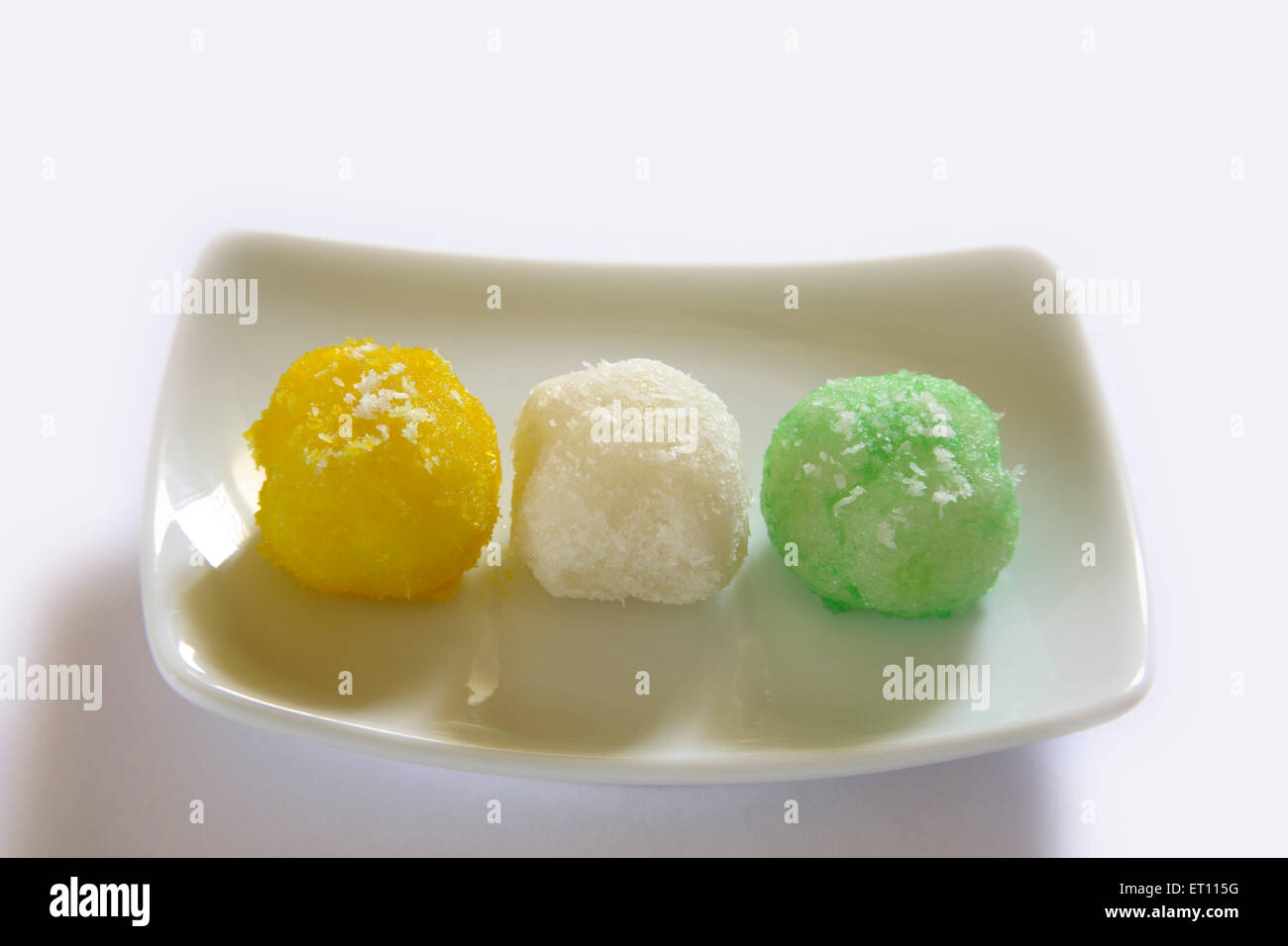Mithai ; colourful nariyal ka laddoos in rectangle plate on white background Stock Photo