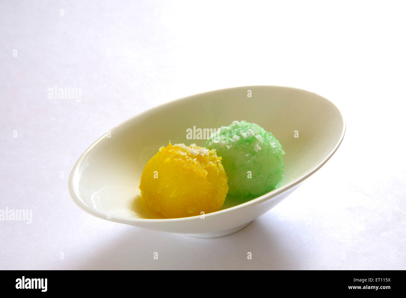 Mithai ; colourful nariyal ka laddoos in oval plate on white background Stock Photo