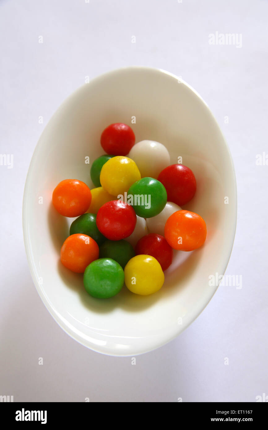 Colourful sweet and sour ball or marble in oval plate on white background Stock Photo