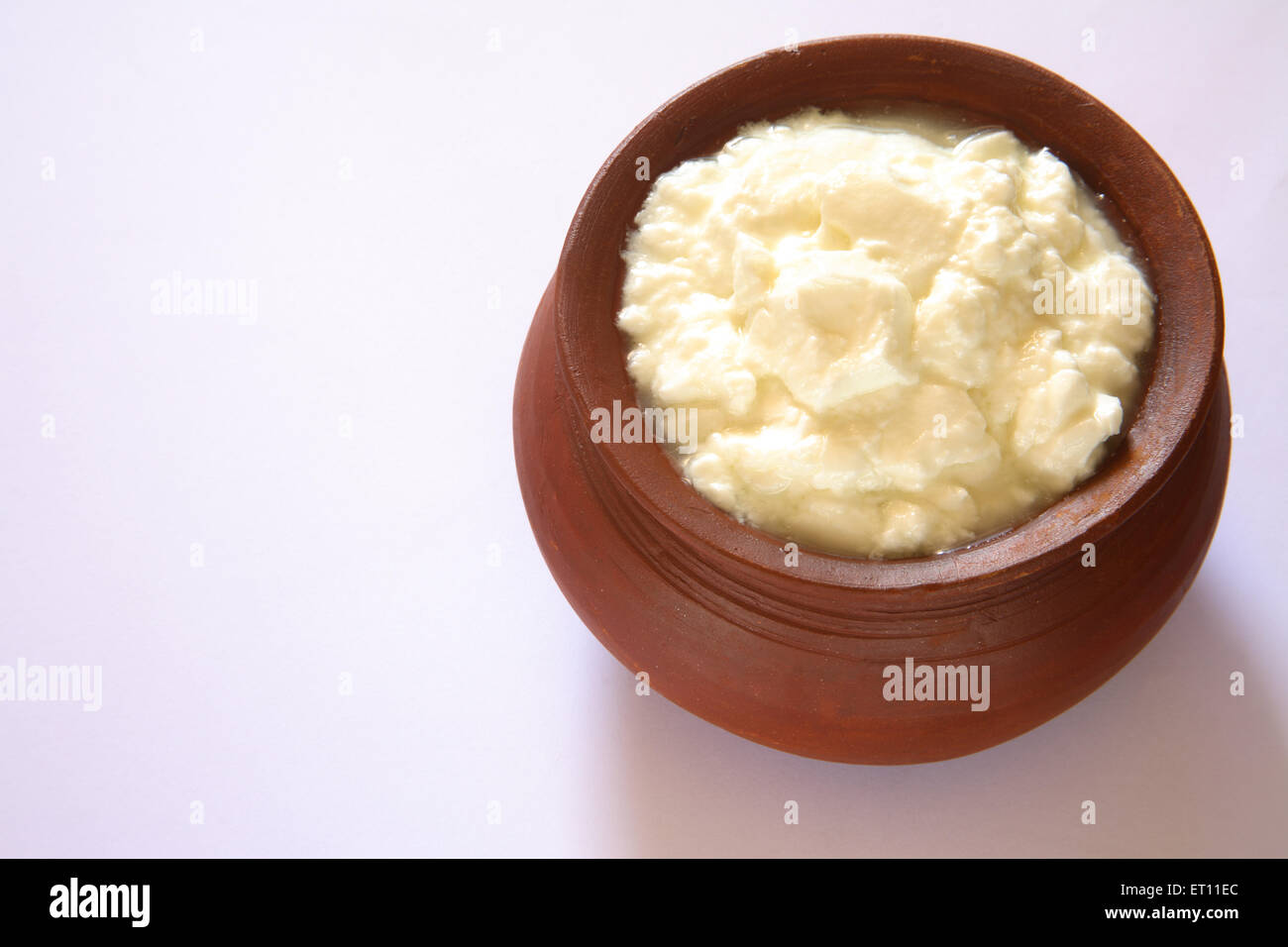 Curd in earthen pot on white background Stock Photo