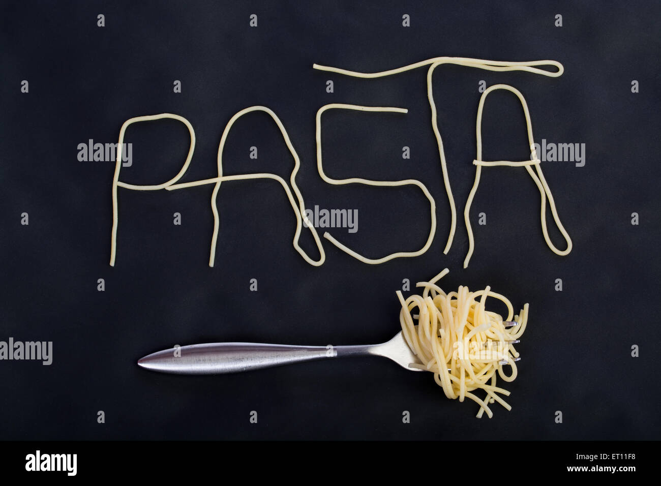 Word pasta made of cooked spaghetti with fork with rolled spaghetti on
