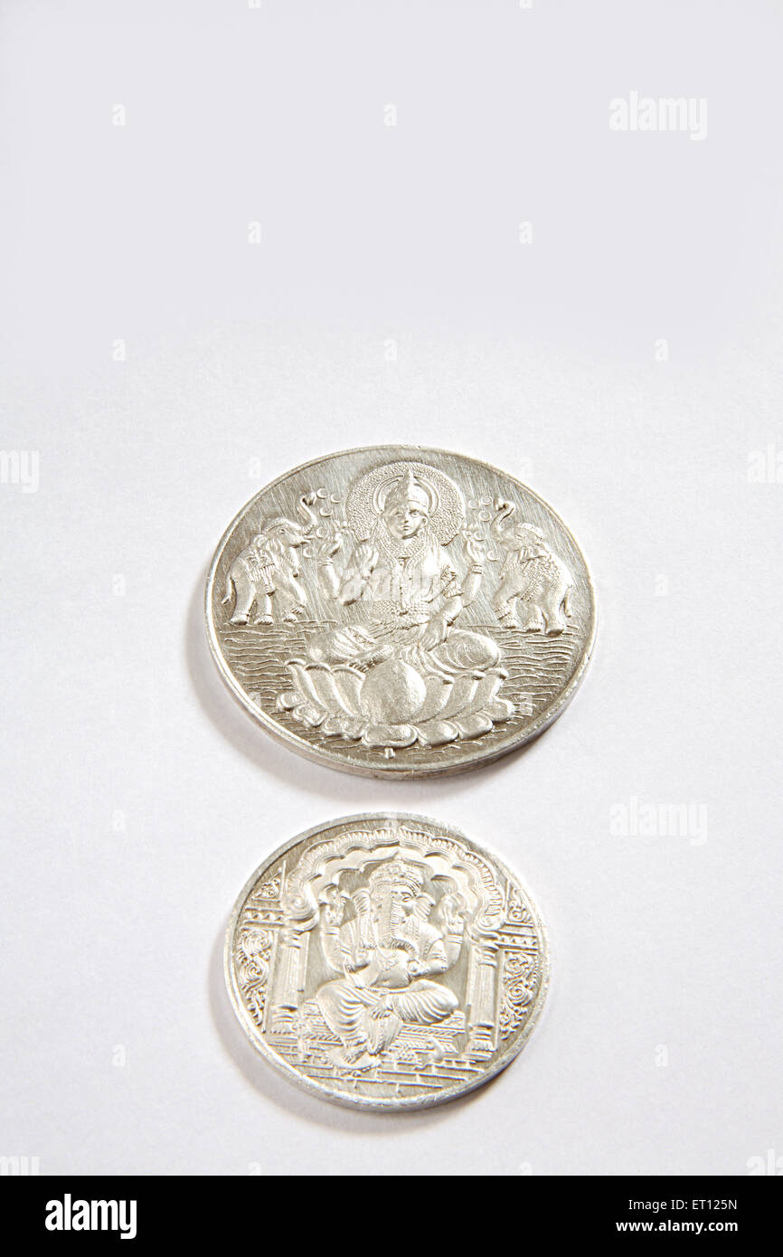 Concept ; silver coins of god ganesh and goddess lakshmi on white background Stock Photo