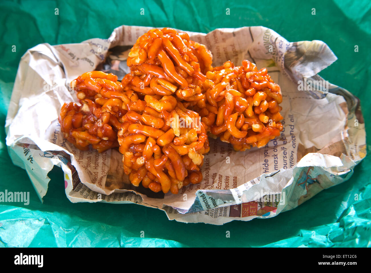 mithai ladoo of gathia and jaggery on newspaper and green wrapper Stock Photo