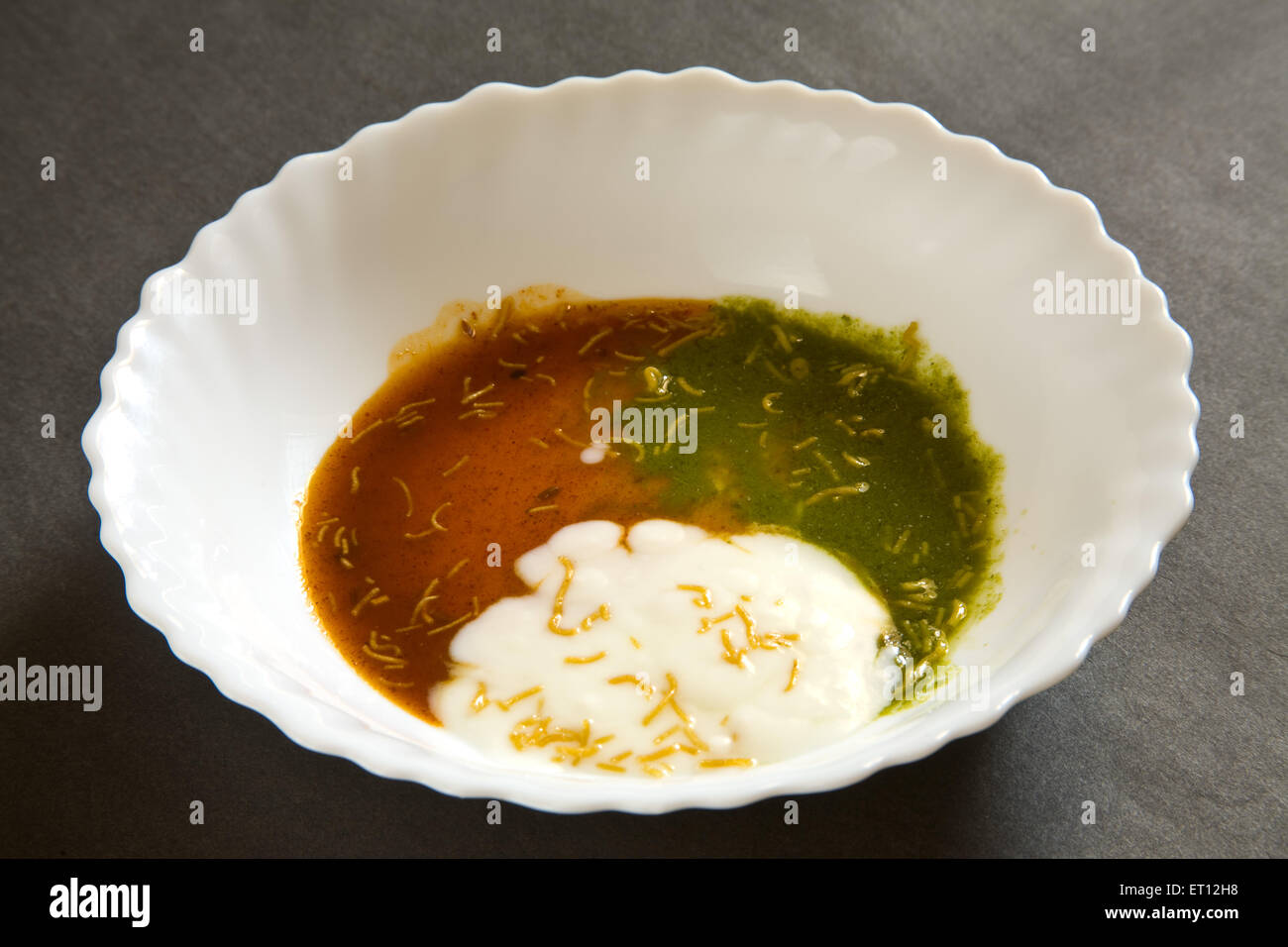 yogurt green coriander and tamarind chutney in white ceramic bowl on