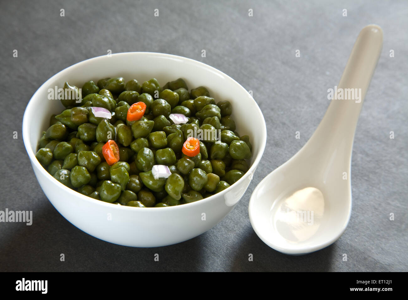Indian breakfast green chickpeas chana salad served in bowl with spoon