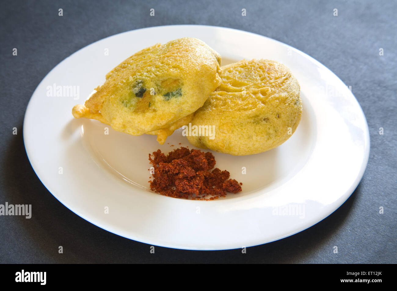 Indian fast food fried batata potato vada with red chutney served in