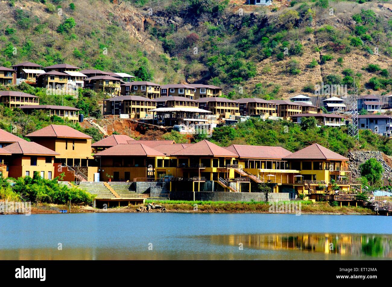 Buildings and bungalows on warasgaon lake ; Pune ; Maharashtra ; India Stock Photo
