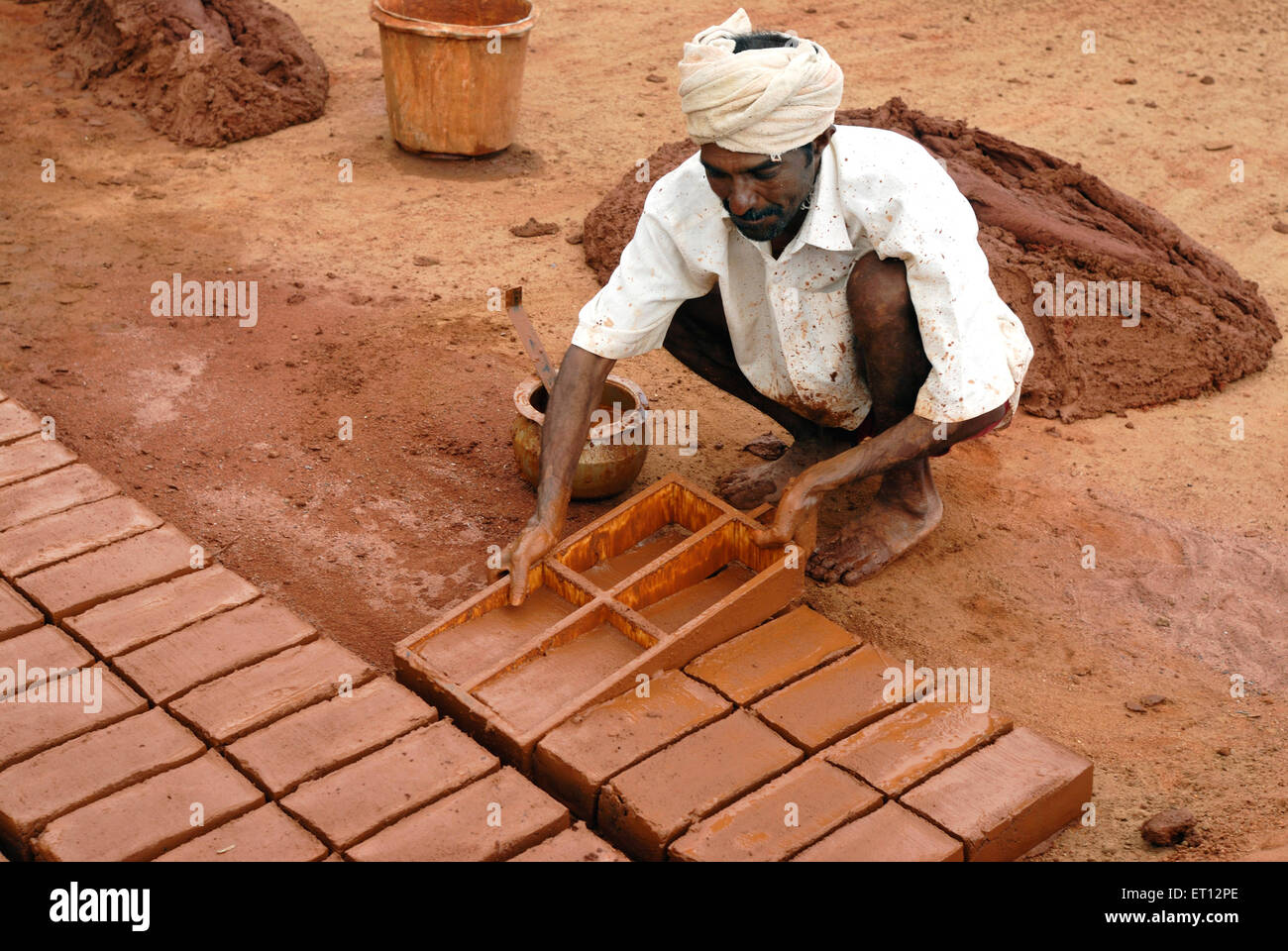 worker moulding earthen bricks ; Tamil Nadu ; India Stock Photo