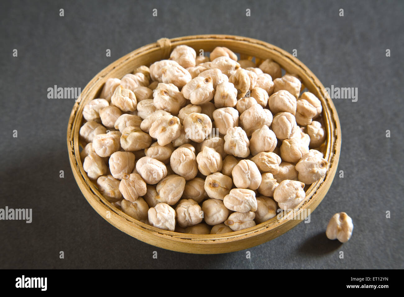Grain ; chickpeas gram cicer arietinum in cane bowl on grey background 19 May 2010 Stock Photo