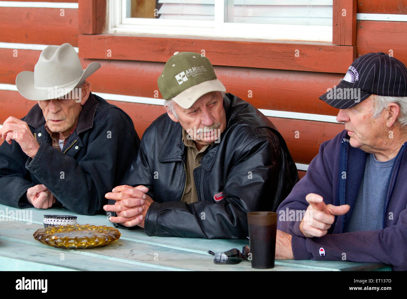 Old farmers smoking and talking outside a cafe in eastern Idaho, USA. Stock Photo