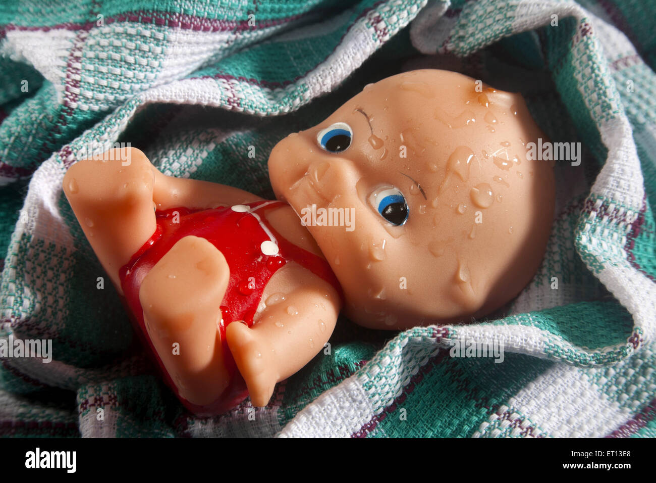 Toy Baby made from Rubber on Cotton fabric Towel India Asia Sept 2011 Stock Photo