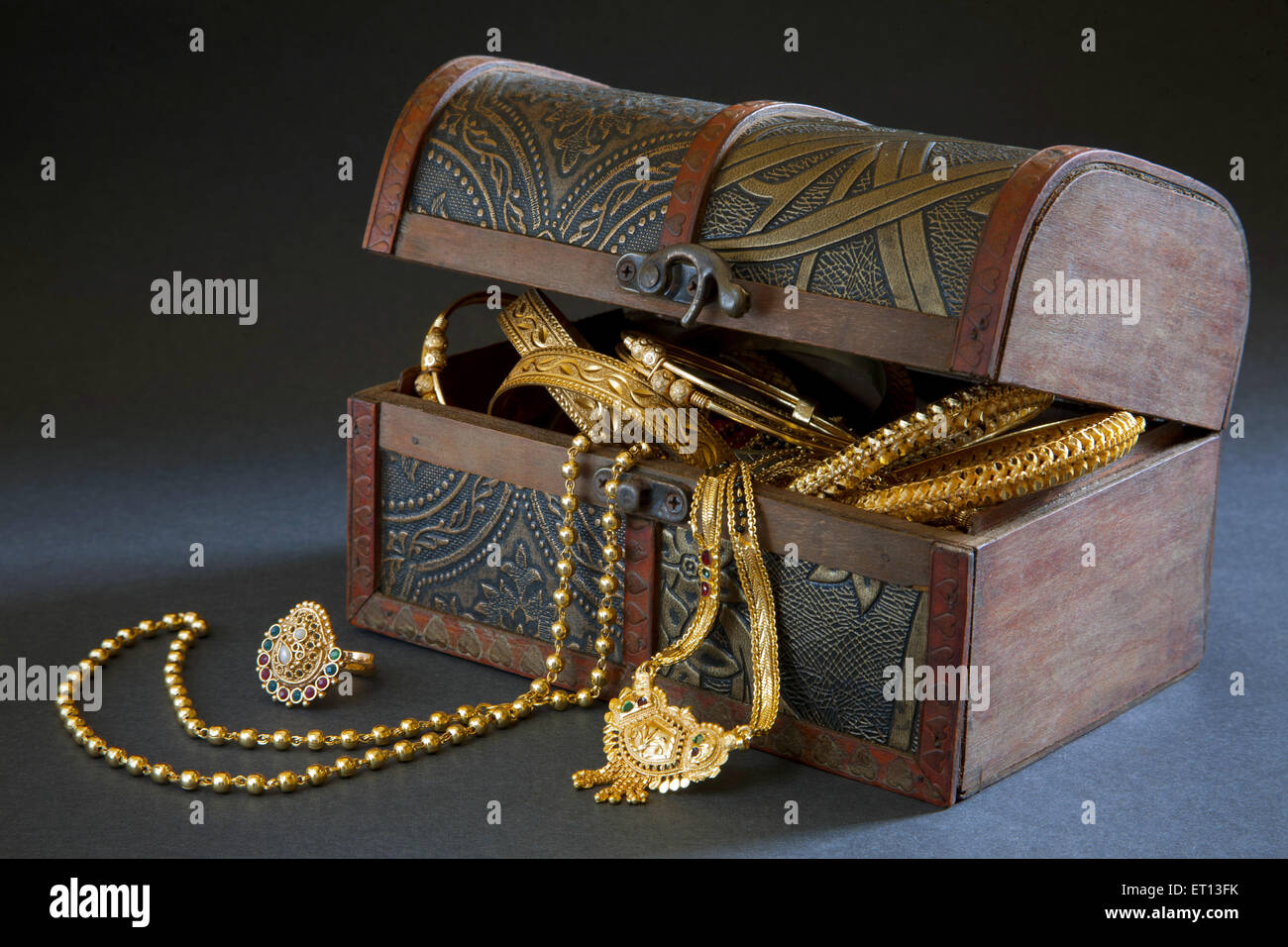 Wooden jewellery box with gold bangles gold necklace gold ring Stock Photo