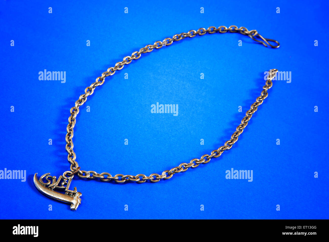 Necklace with metal charm amulet pendant on blue background Stock Photo