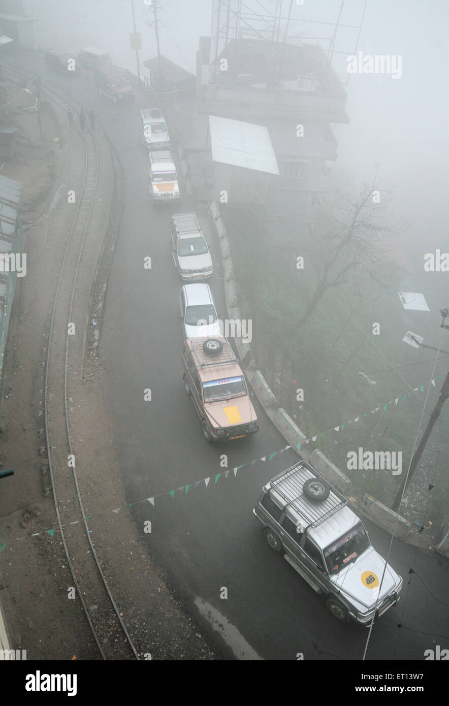 Aerial of traffic on the road with train tracks ; Darjeeling ; West Bengal ; India Stock Photo