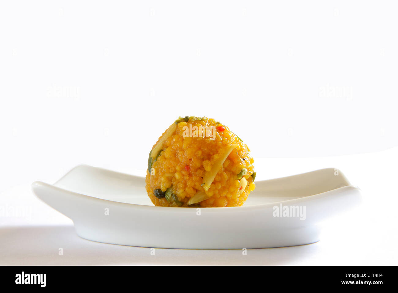 Mithai ; one piece of motichur or boondi dryfruit laddoo in rectangle plate on white background Stock Photo