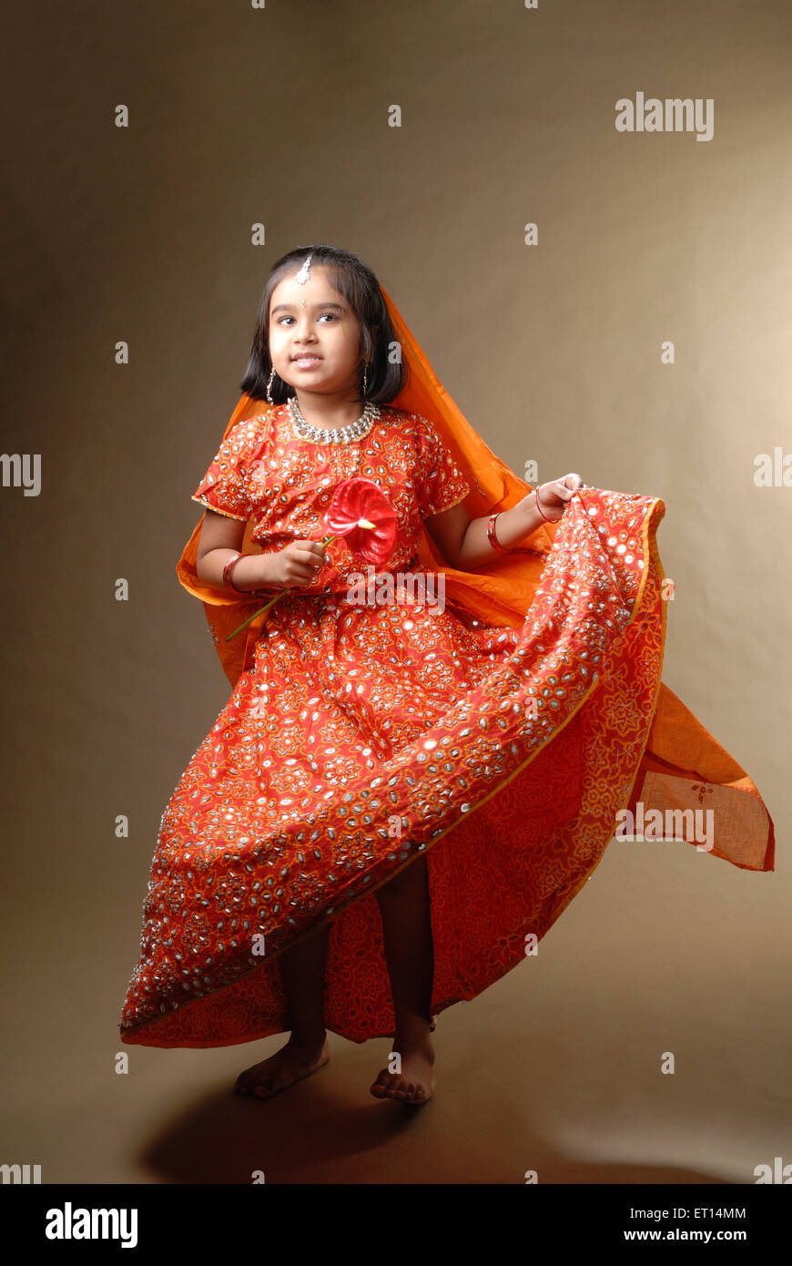 Young girl in ghagra choli holding anthurium flower MR#719D Stock Photo