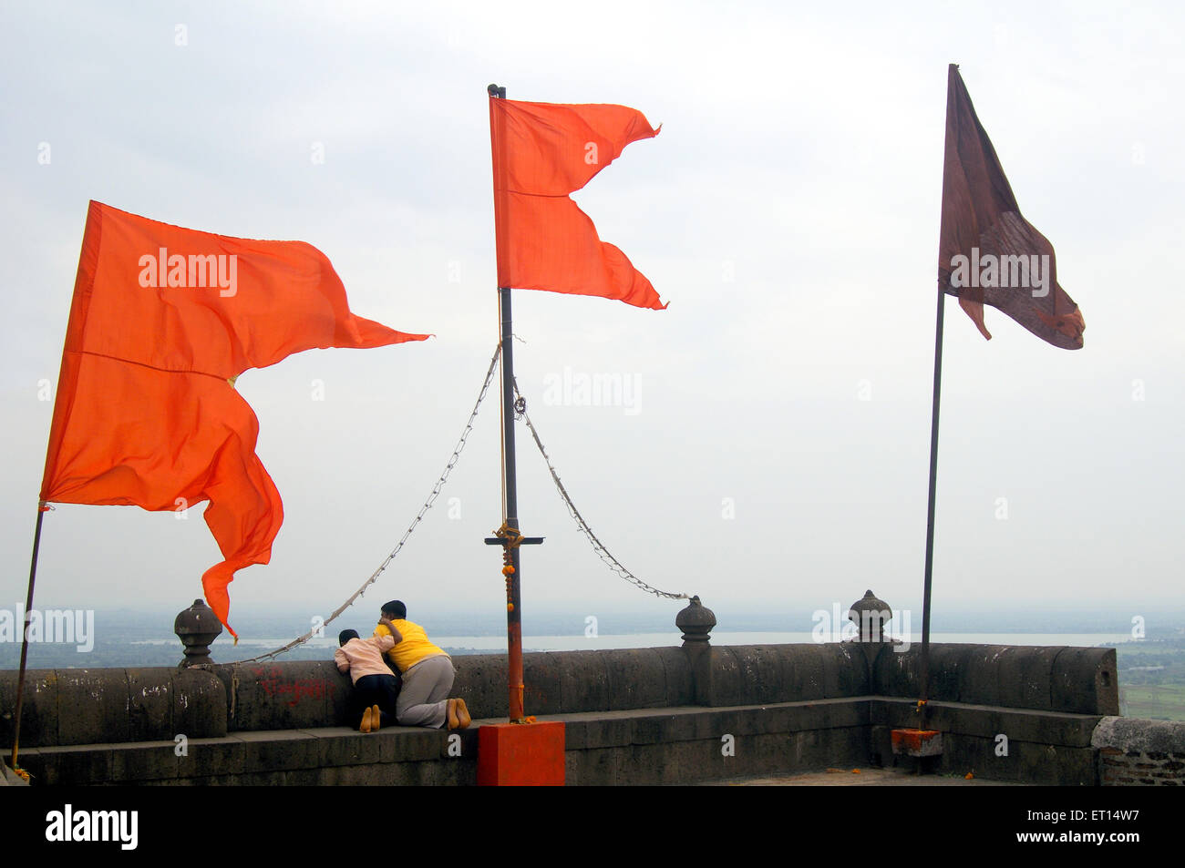 Orange flags flying on wall of vithobha temple ; Jejury ; Pune ; Maharashtra ; India Stock Photo
