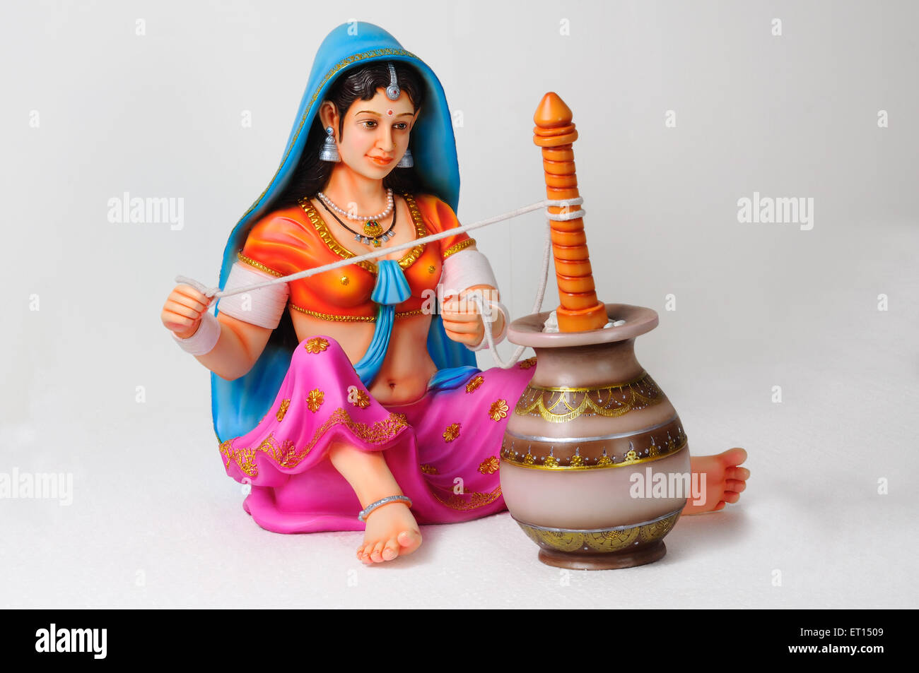 Clay figurine ; statue of rajasthani woman with churning pot preparing buttermilk Stock Photo