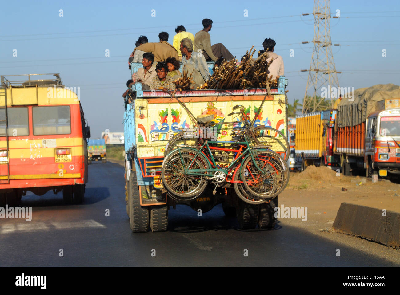Truck on highway carrying passengers and bicycles hanging Stock Photo