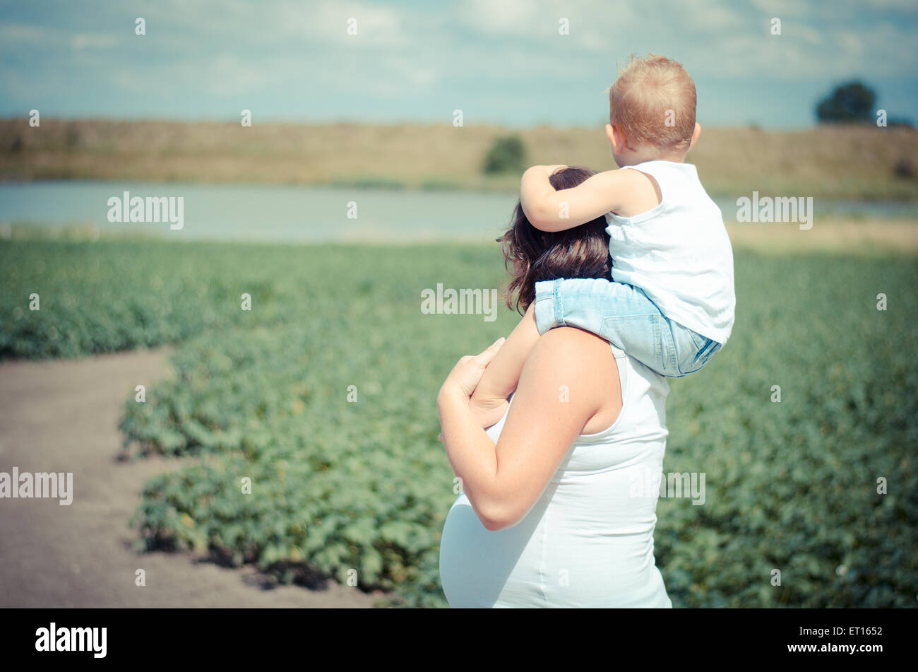 pregnant woman with boy on her neck Stock Photo