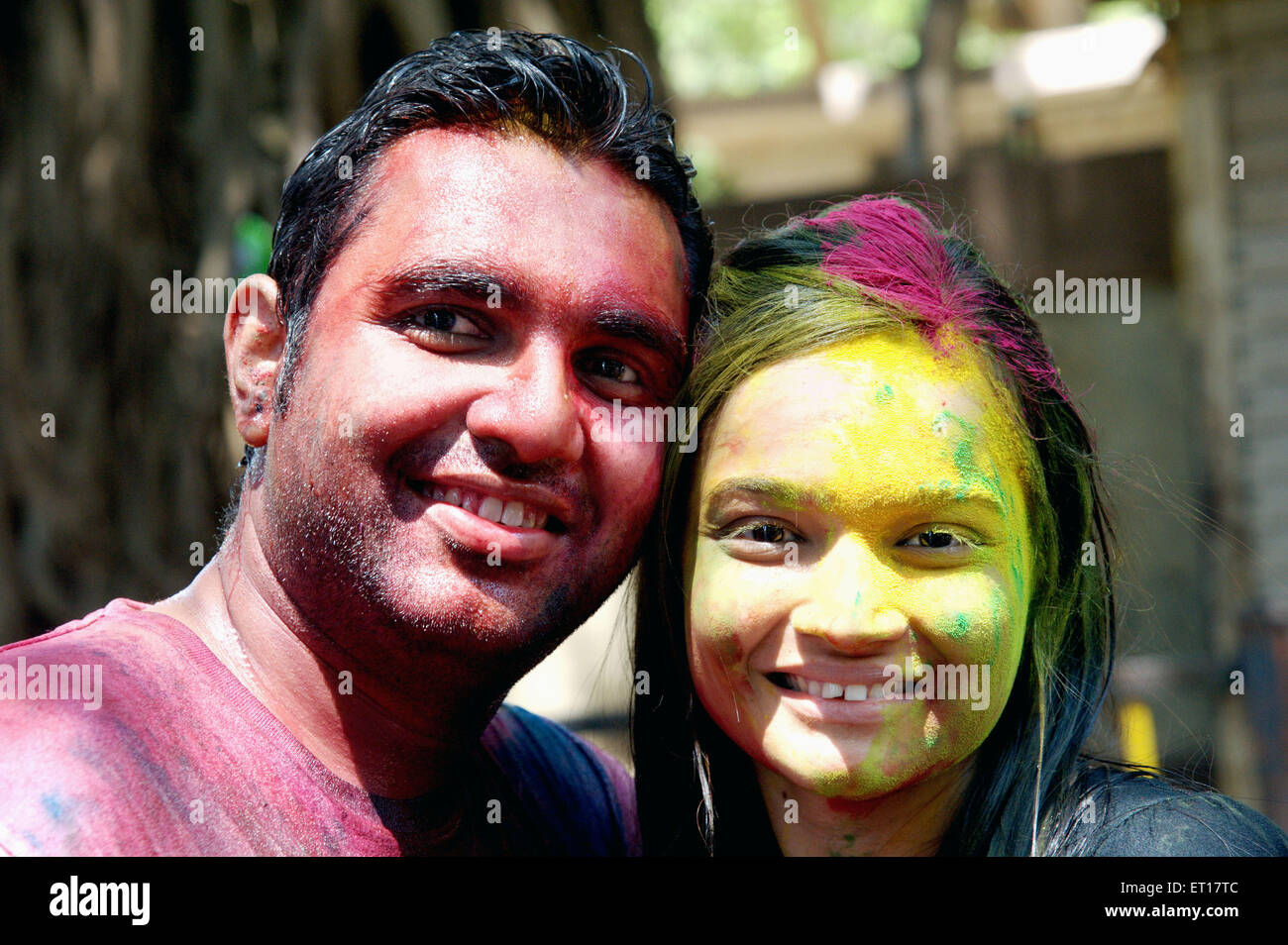Indian couple faces smeared with color powder celebrating Holi Festival of colours India MR#364 Stock Photo