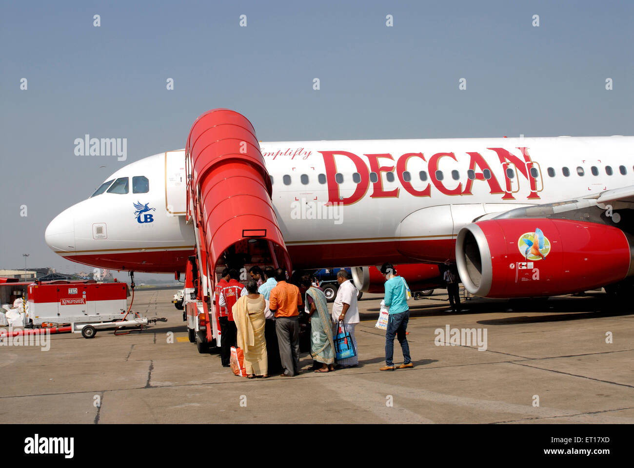 Passenger arriving in red and white deccan aeroplane at airport ; India No MR Stock Photo