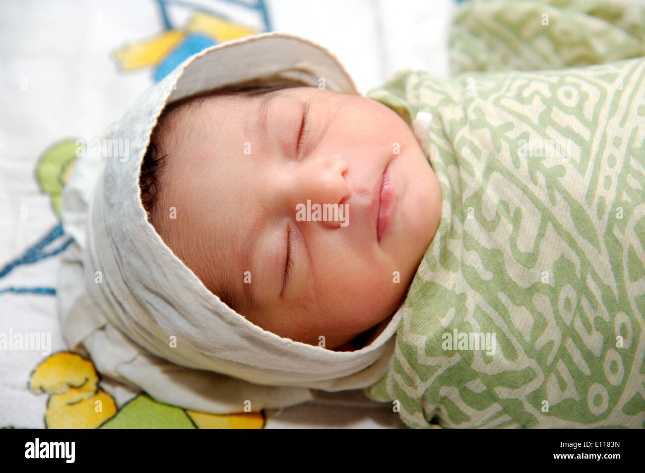 Newborn baby sleeping wrapped printed fabric - Model Released # 736LA - rmm 179664 Stock Photo