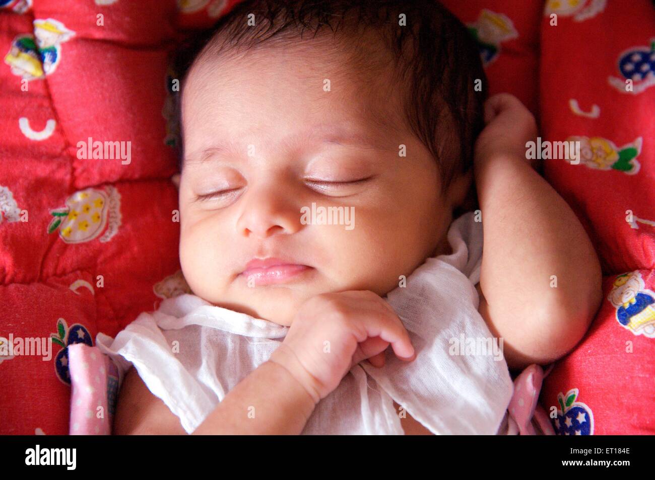 Indian baby girl child sleeping red background - MR#736LA - rmm 179684 Stock Photo