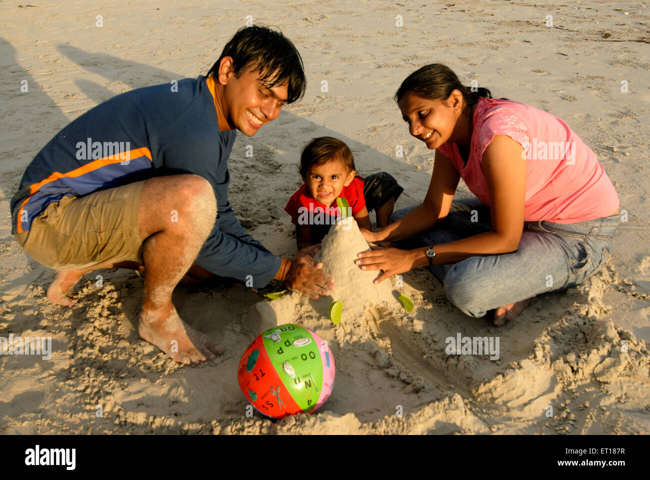 Parents with daughter making sandcastle ; Andaman and Nicobar Islands ; India MR#736J;736K;736L November 2008 Stock Photo