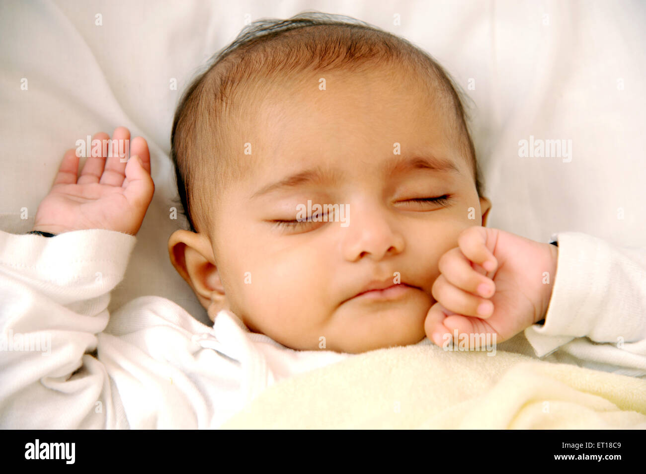 Baby sleeping on bed with hand on cheeks MR736LA Stock Photo Alamy