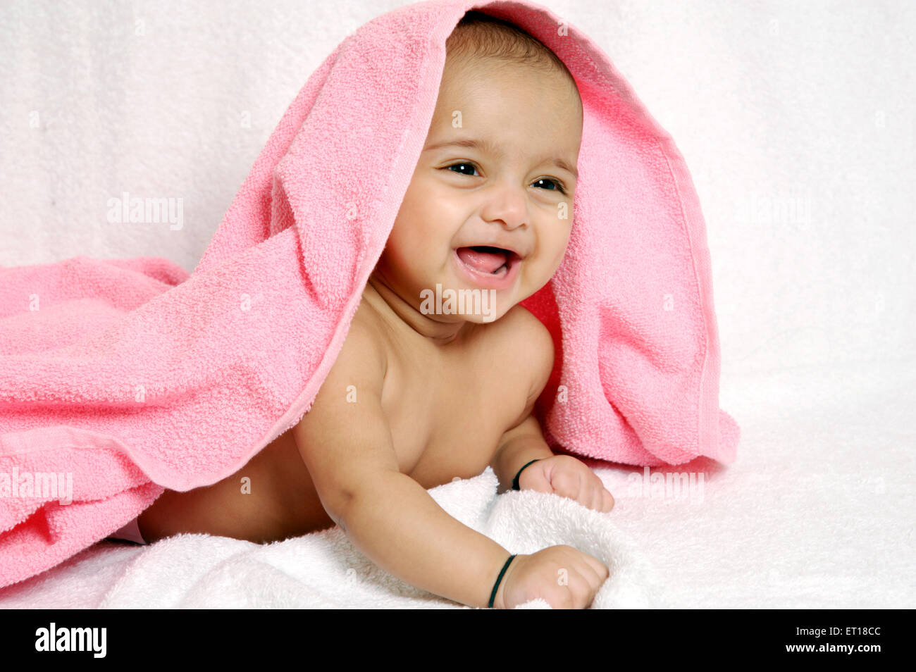 baby under pink towel on white background MR#736LA Stock Photo