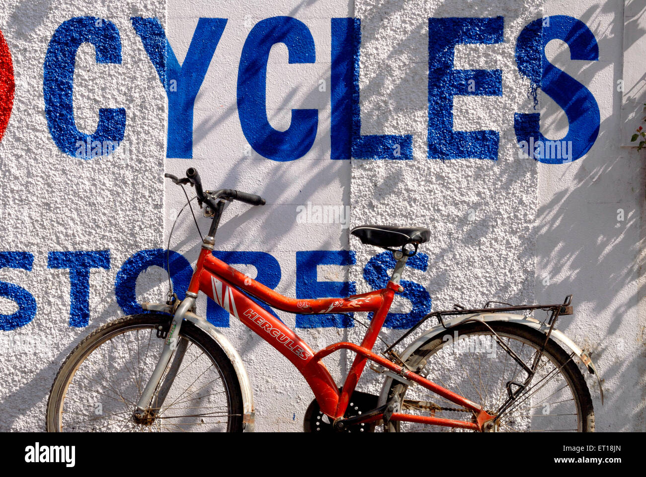 Bicycle Hercules resting parked against wall with sign Cycles Stores, India Stock Photo