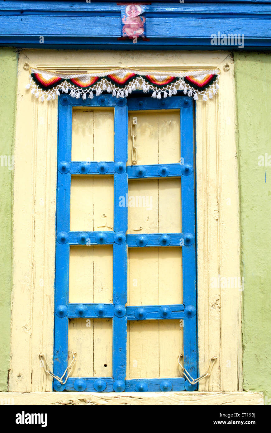 Old door painted with blue and yellow color Stock Photo