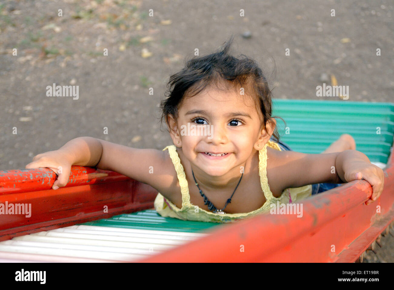 Indian young girl child sliding stomach - MR#736L Stock Photo