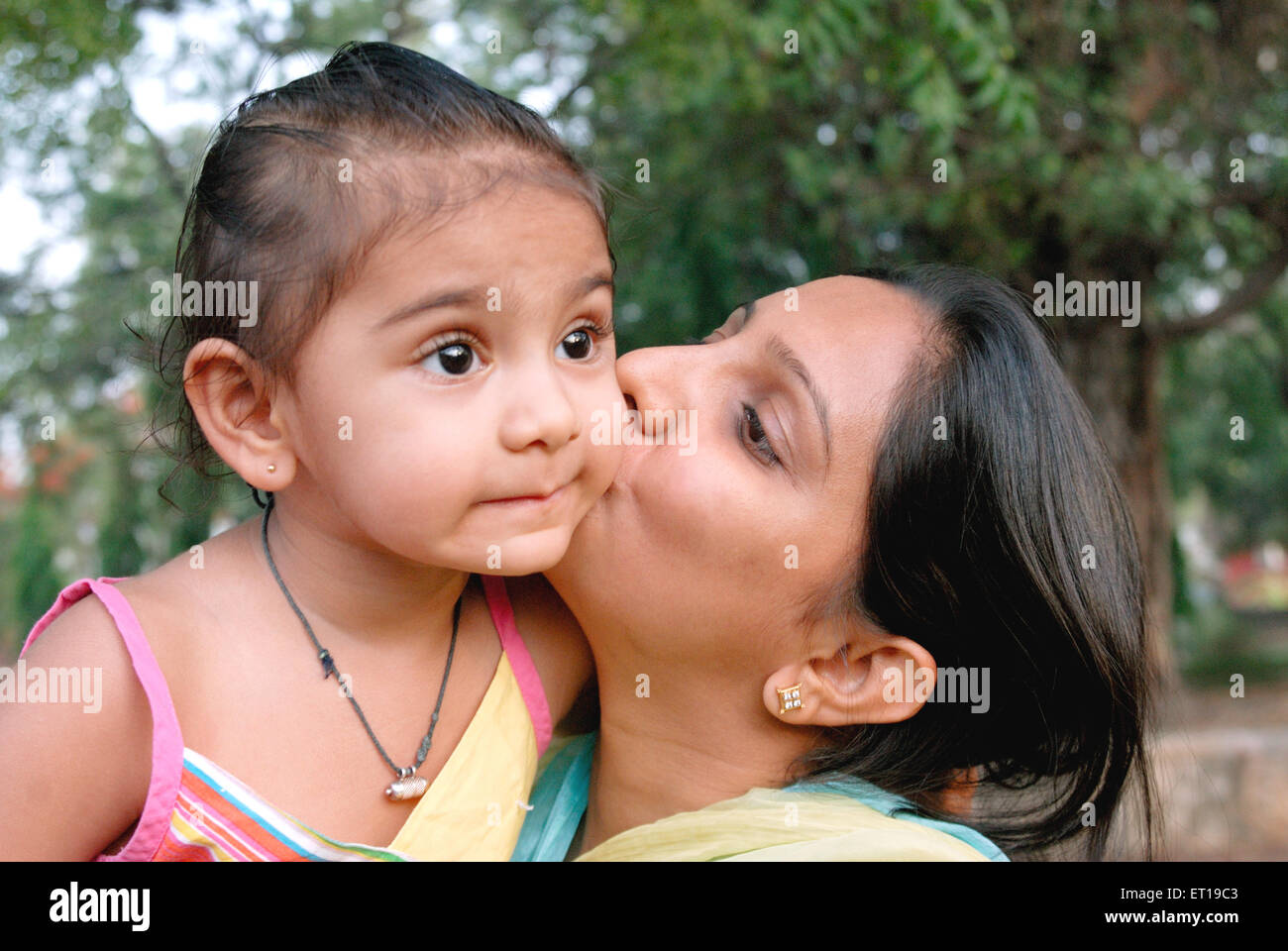 Indian mother kissing daughter on cheeks - MR#736K&L - rmm 167203 Stock Photo