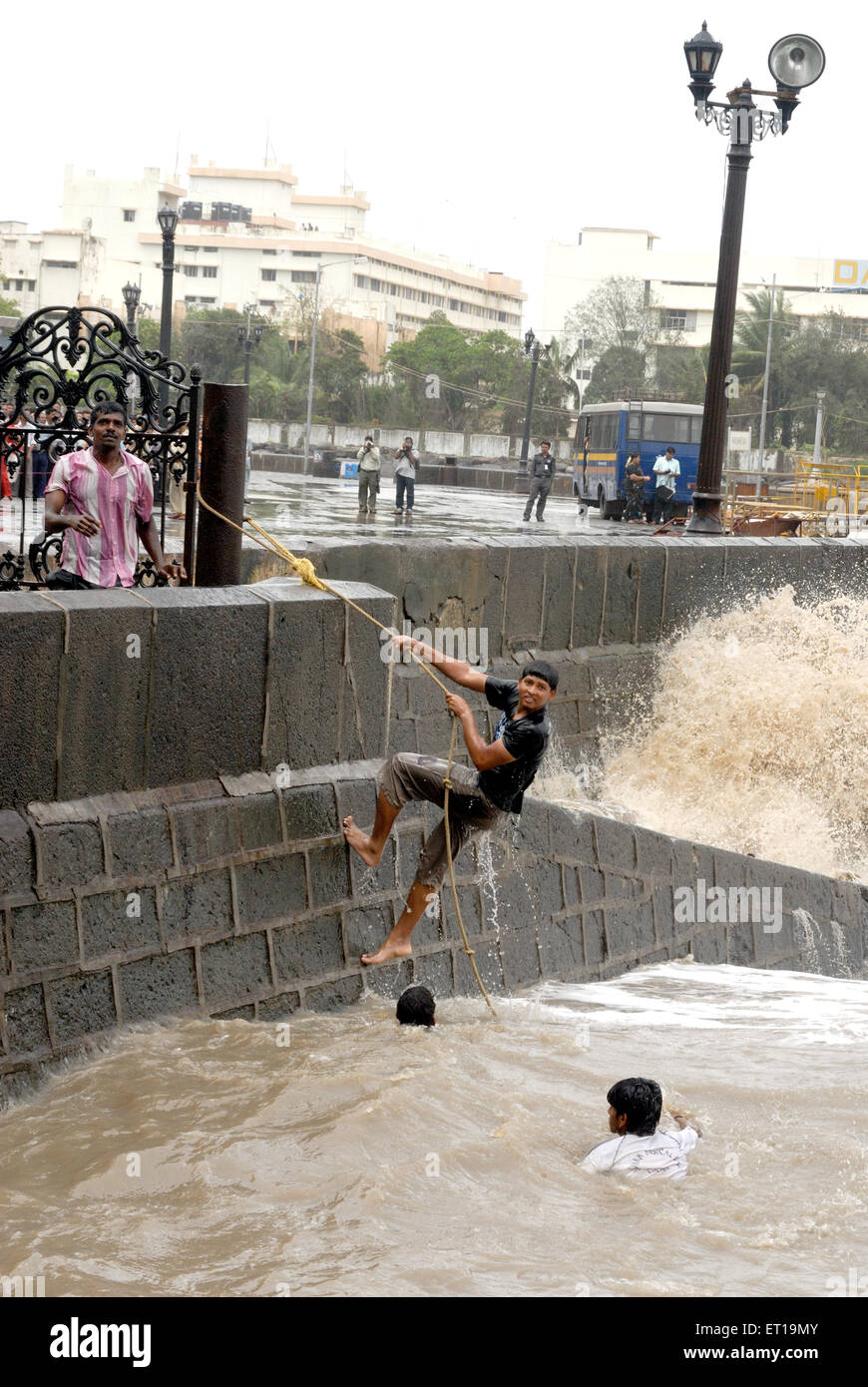 Boy climbing with rope in high tide at Apollo Bunder, Gateway of India