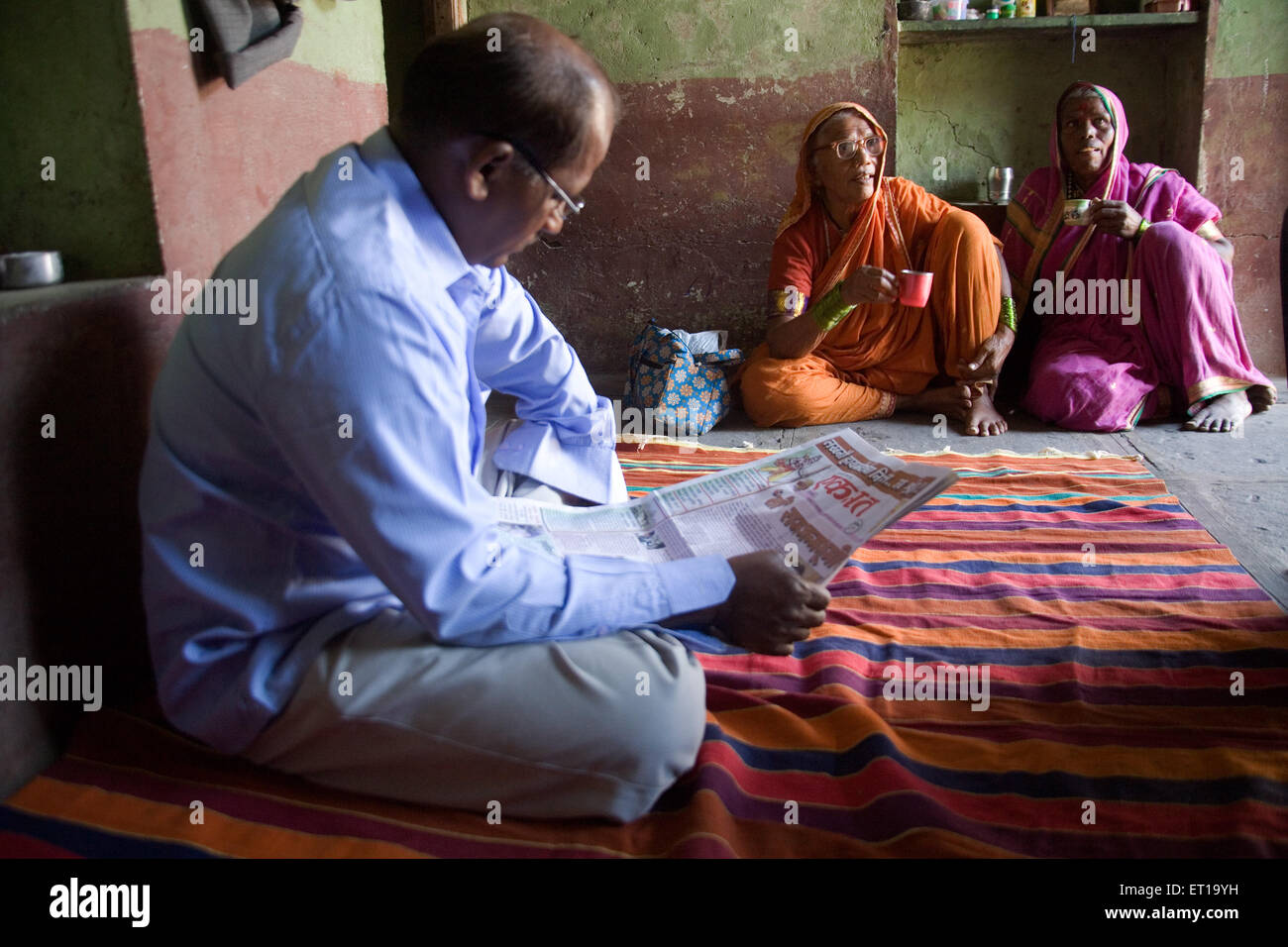 Man reading newspaper in house ; Salunkhewadi ; Nandur ; Marathwada ; Maharashtra ; India MR#688 Stock Photo