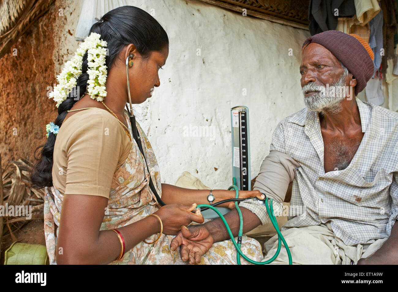 Health worker NGO Chinmaya Organization Rural Development CORD checking blood pressure mercury patient doorstep Siruvani, Palakkad, Kerala, India Stock Photo