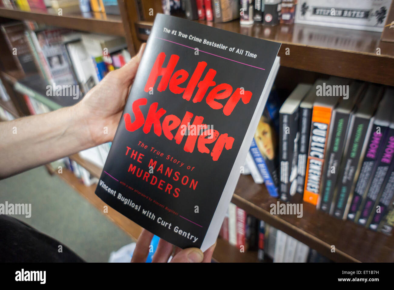 A reader contemplates a copy of 'Helter Skelter', the story of the Charles Manson cult murders, by Vincent Bugliosi in a bookstore in New York on Wednesday, June 10, 2015. Bugliosi, who was the prosecutor in the Manson case, won convictions of Manson and his followers in the brutal murder of actress Sharon Tate and six other people. Bugliosi died of cancer in Los Angeles at 80. (© Richard B. Levine) Stock Photo