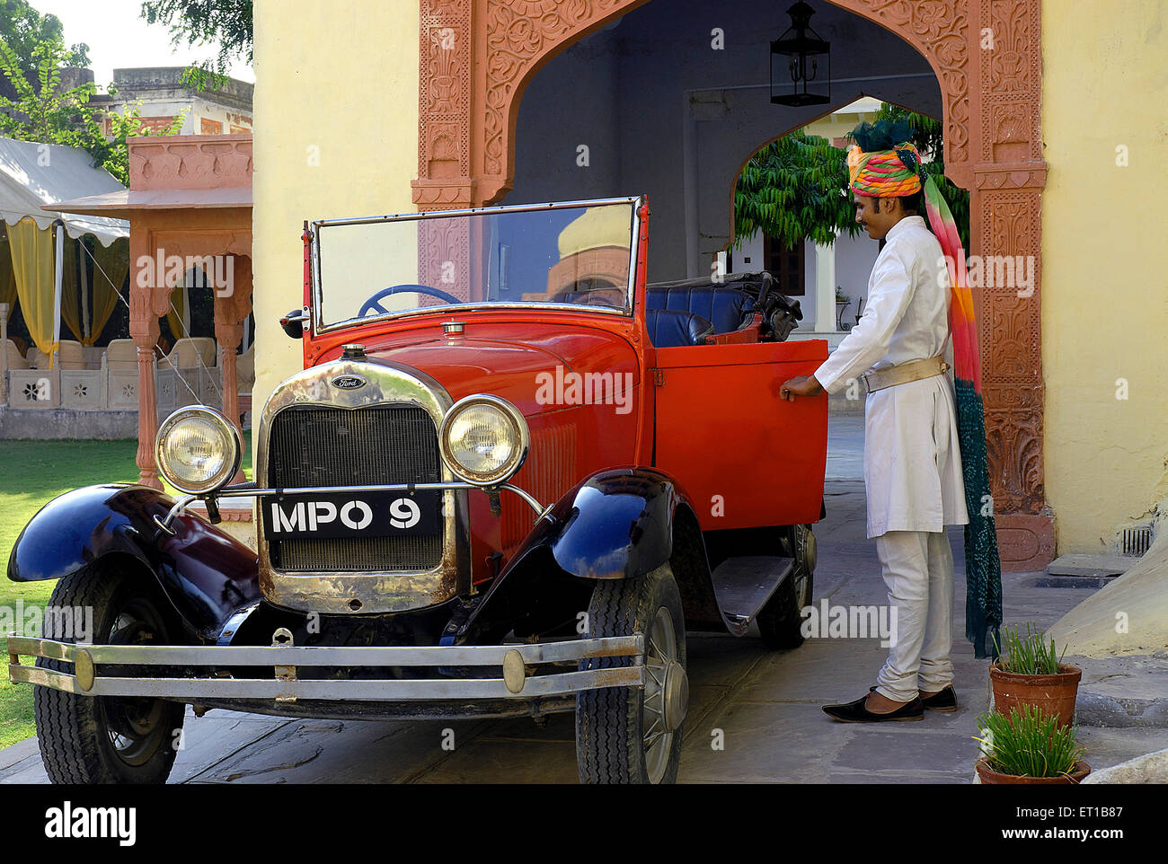 Doorman opening door of vintage car at Rawla Jojwar heritage hotel ; Marwar ; Rajasthan ; India PR#746B Stock Photo
